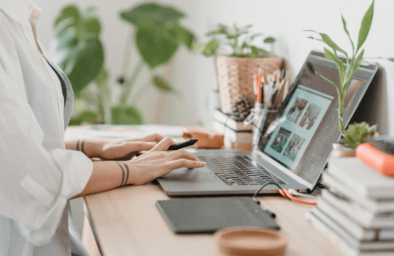 Despre noi - imagine cu un designer ce lucreaza la laptop, cu o placa de desen grafic conectata